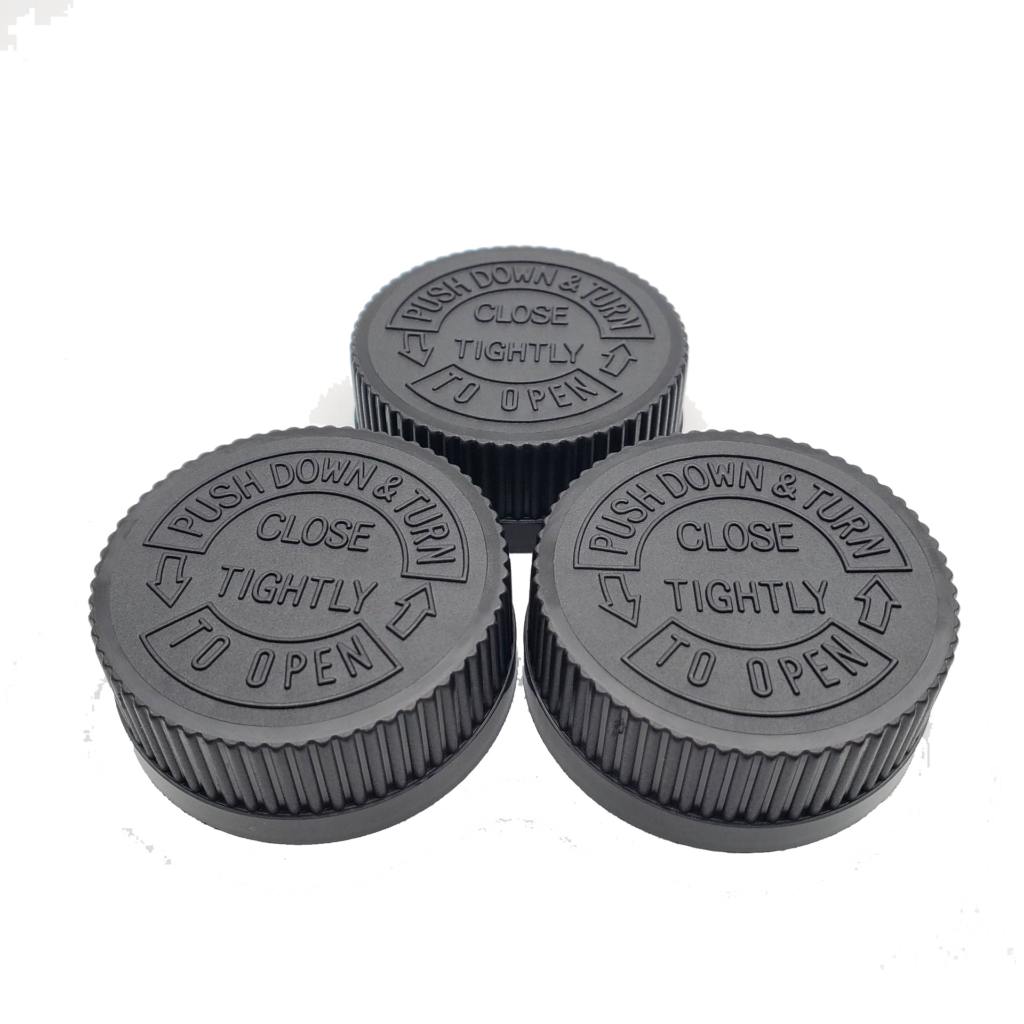 Close up view of three child-resistant container tops.