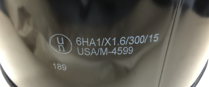 Close up view of a UN marking indicating the ratings and certifications used on steel drums of hazardous materials.